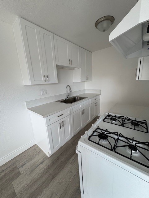 A white kitchen with a stove and cabinets.